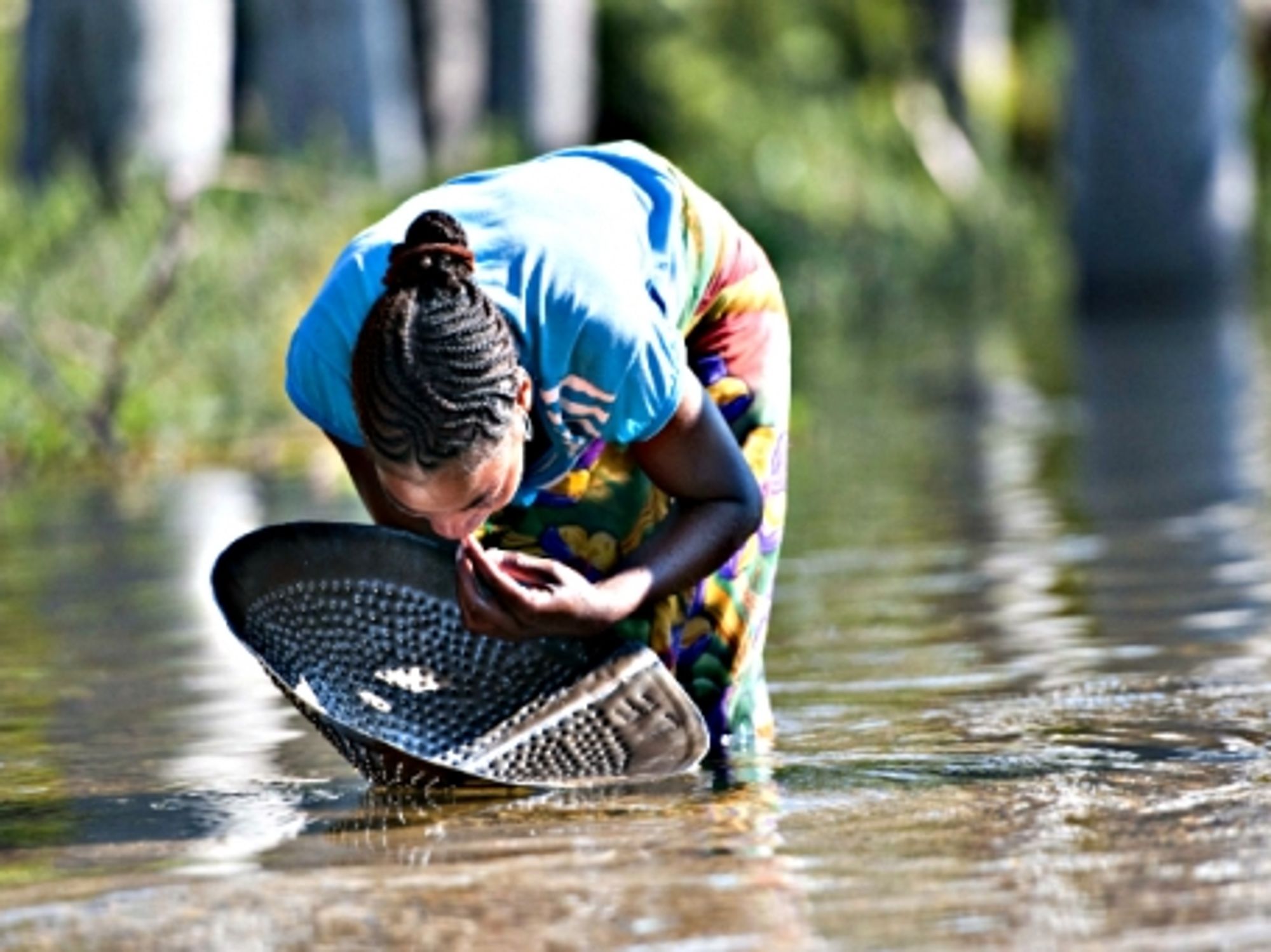 A woman looks for sapphire in a river in Ilakaka in southwest Madagascar