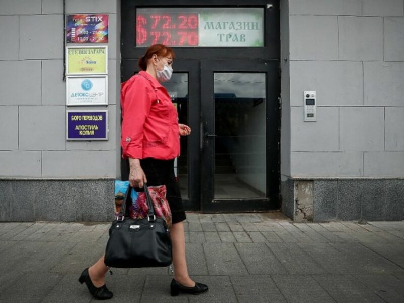 A woman passes a currency exchange office in Moscow, Russia