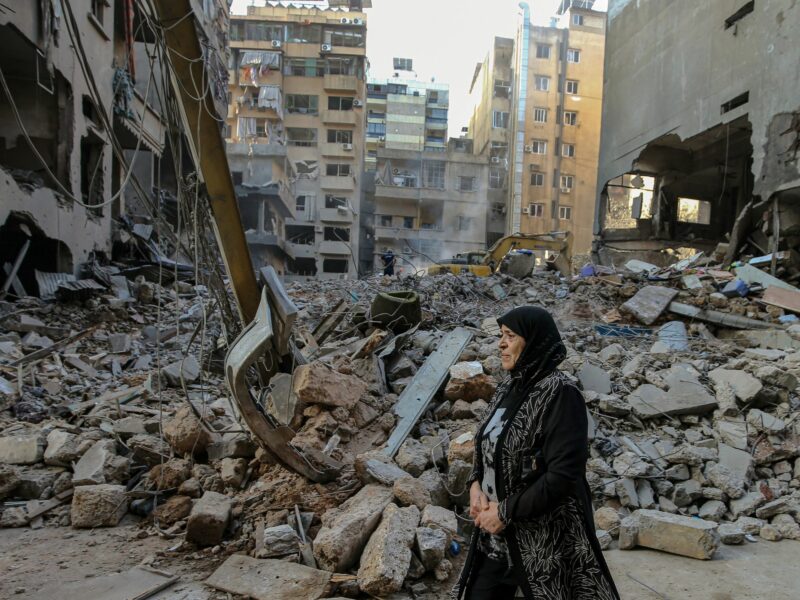 A woman reacts as she walks in front of flattened buildings that were targeted by Israeli air raids in central Beirut. At least 22 people were killed and 117 others were wounded,