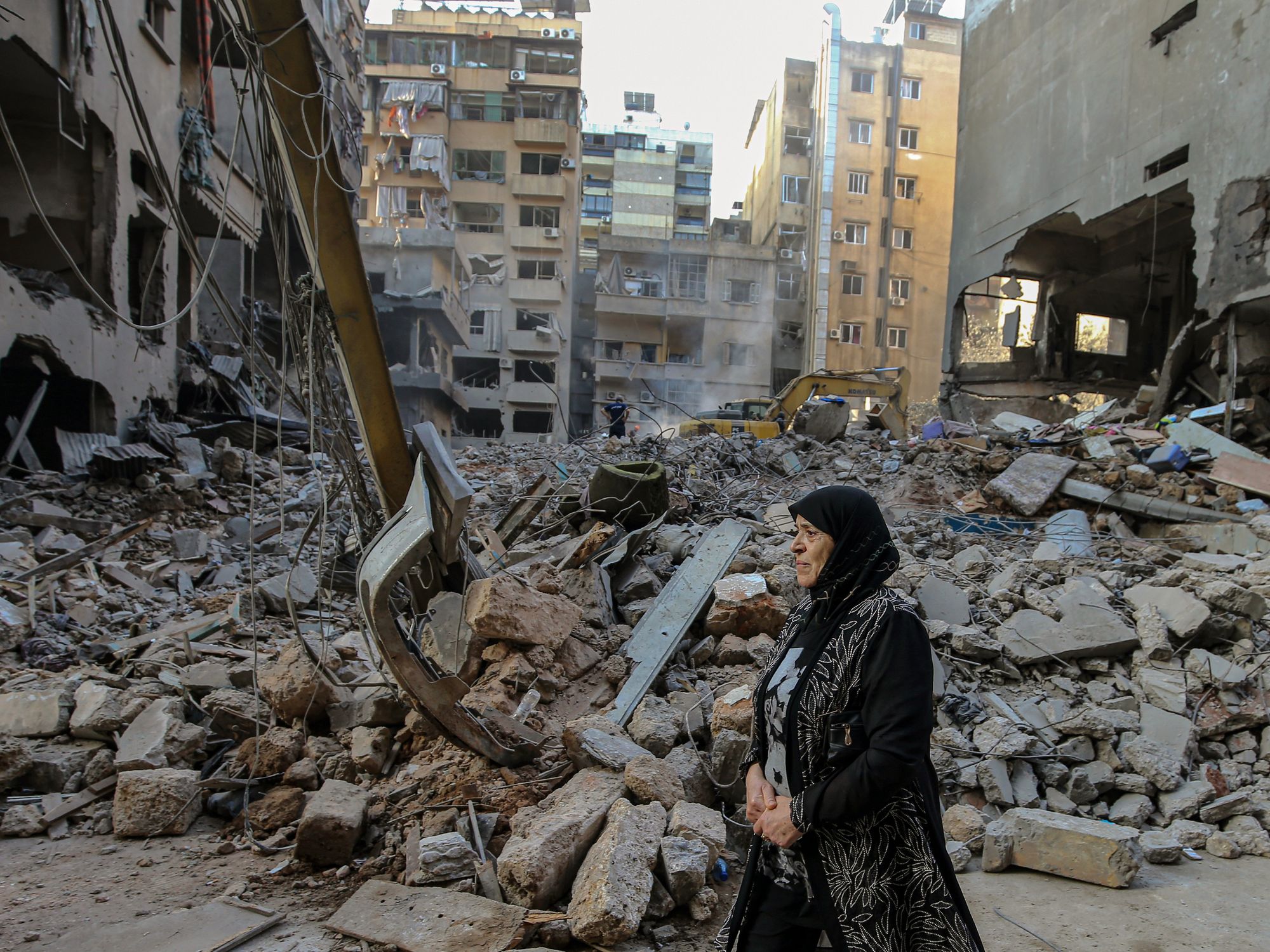 A woman reacts as she walks in front of flattened buildings that were targeted by Israeli air raids in central Beirut. At least 22 people were killed and 117 others were wounded,