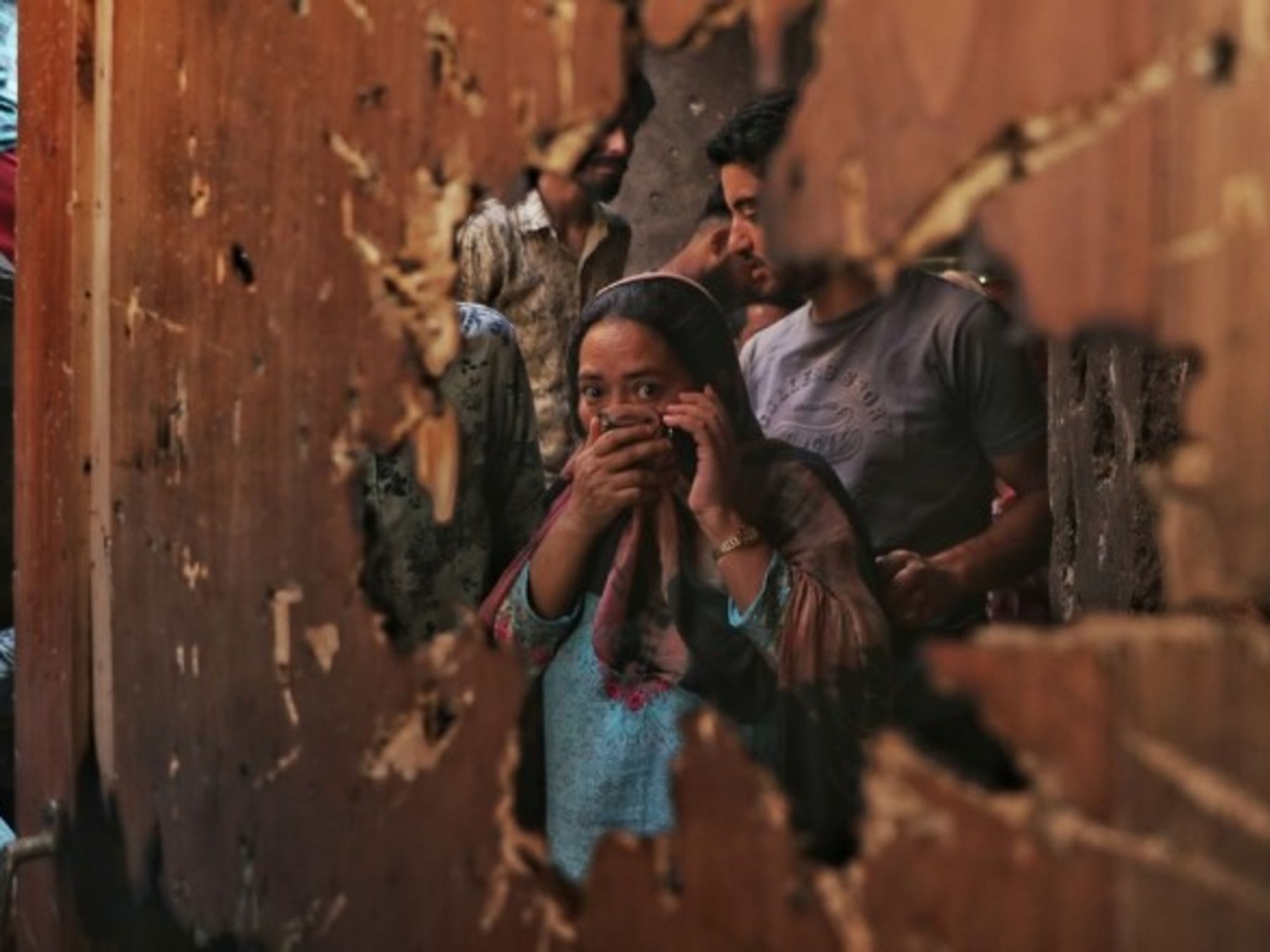 A woman reacts to the damage left from a gunfight between militants and police in the Kashmiri city of Srinagar