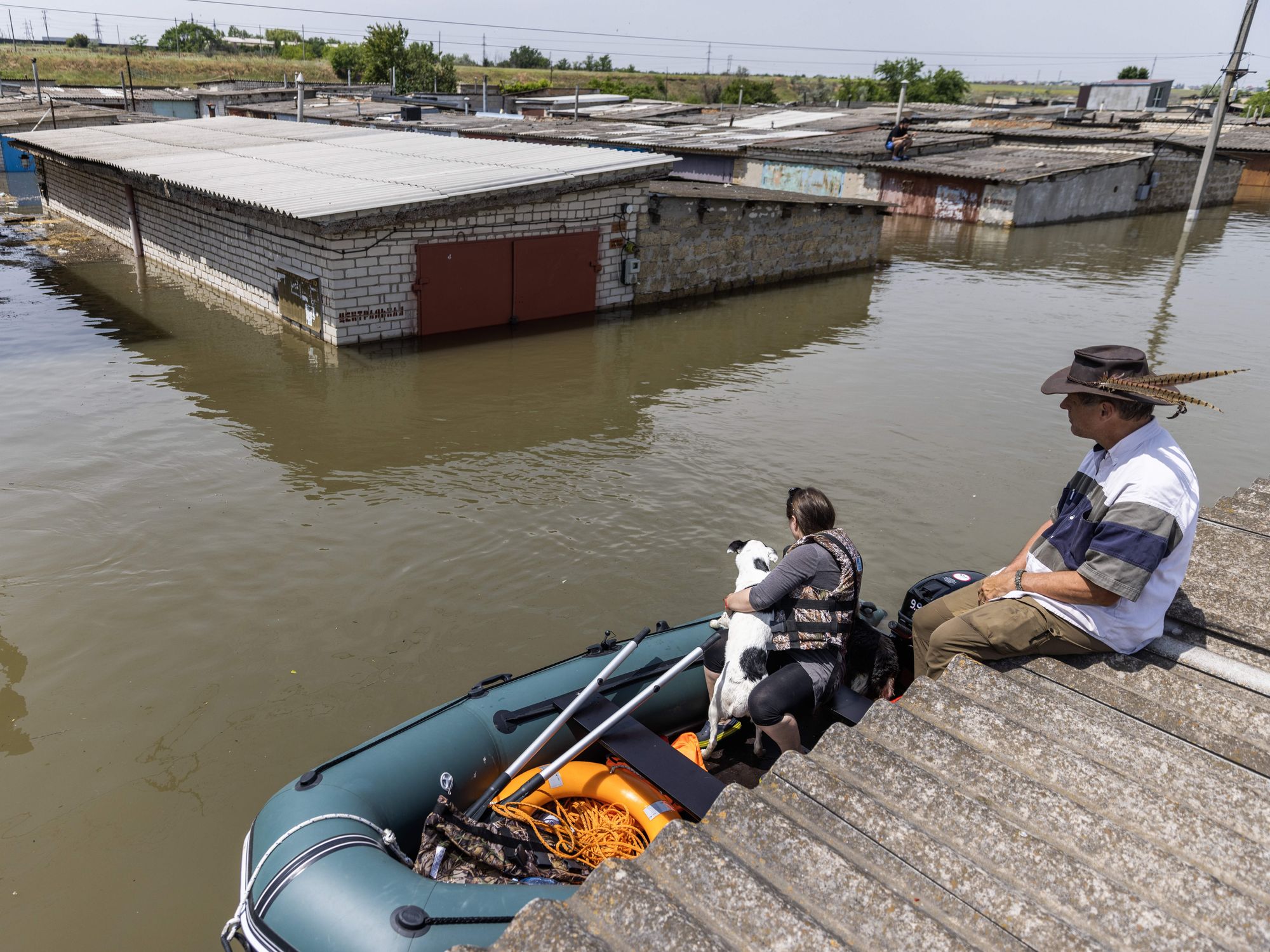 A woman rescues a dog in Kherson, Ukraine, amidst floods.