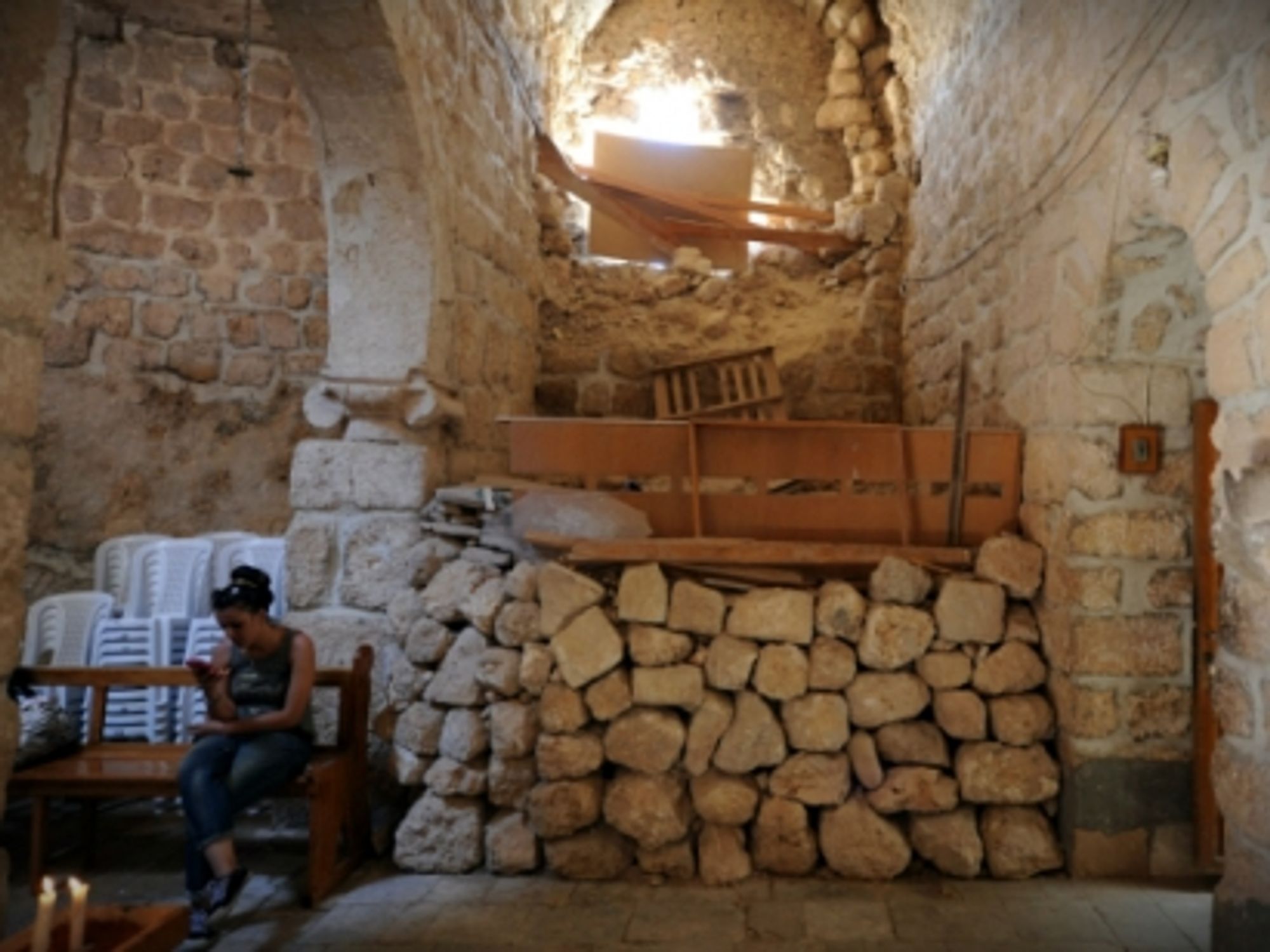 A woman sits in a church in the historic Christian town of Maaloula, north of Damascus