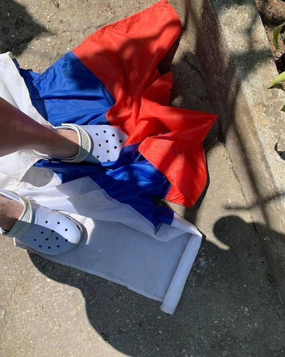 A woman stands on a Russian flag.