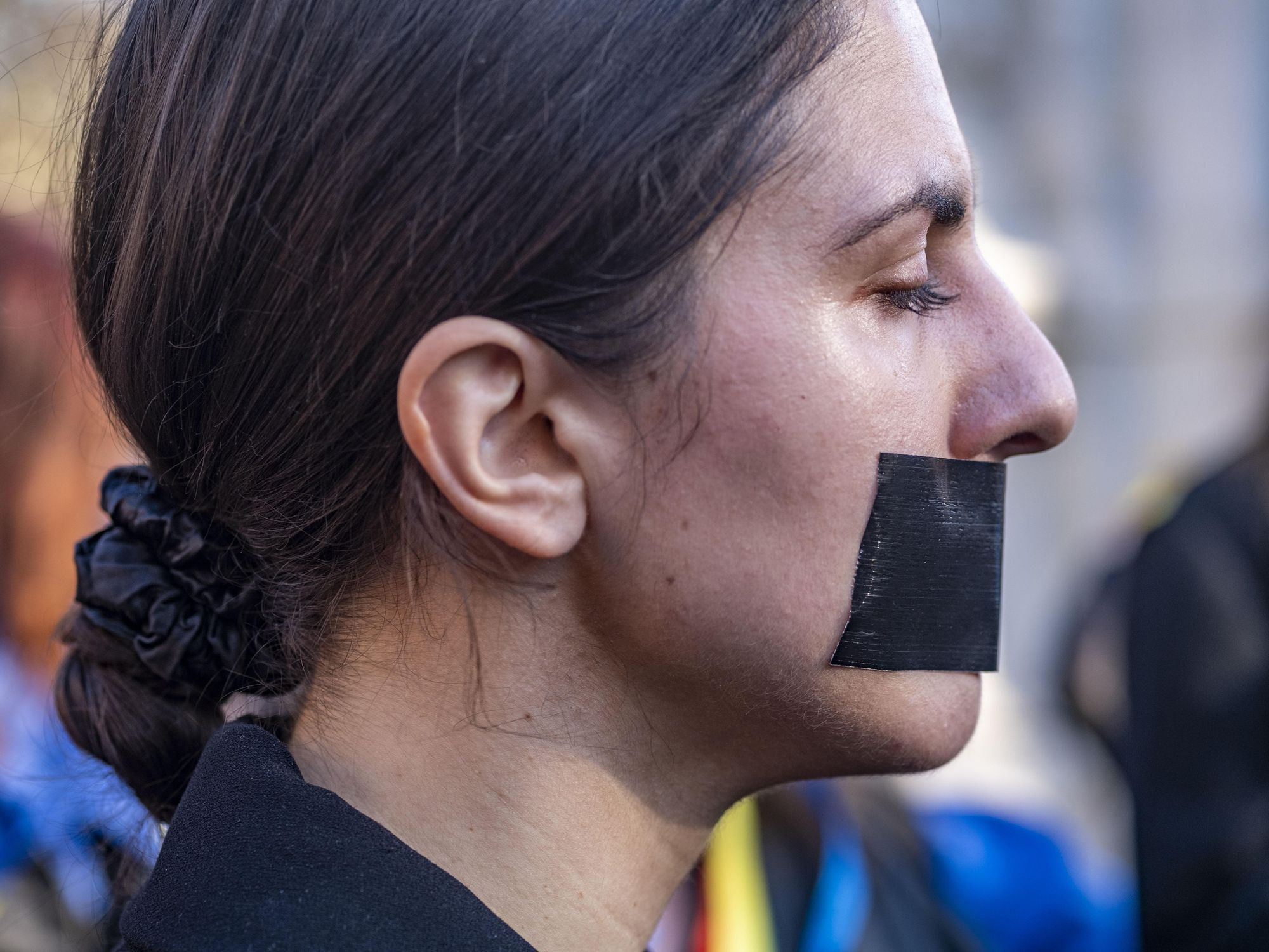 A woman taped her mouth to protest Russian rapes in Ukraine.