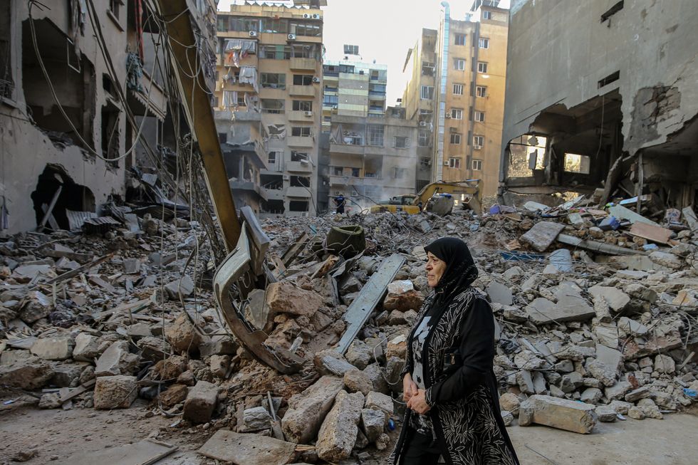 A woman walks in front of buildings that were targeted by Israeli air raids in central Beirut, on the 11th of October 2024.​