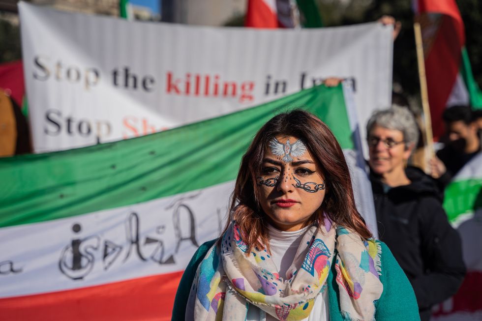 A woman with a dove and chains painted on her face demonstrates in the center of Barcelona in solidarity with the Iranian people​ in January 2023.