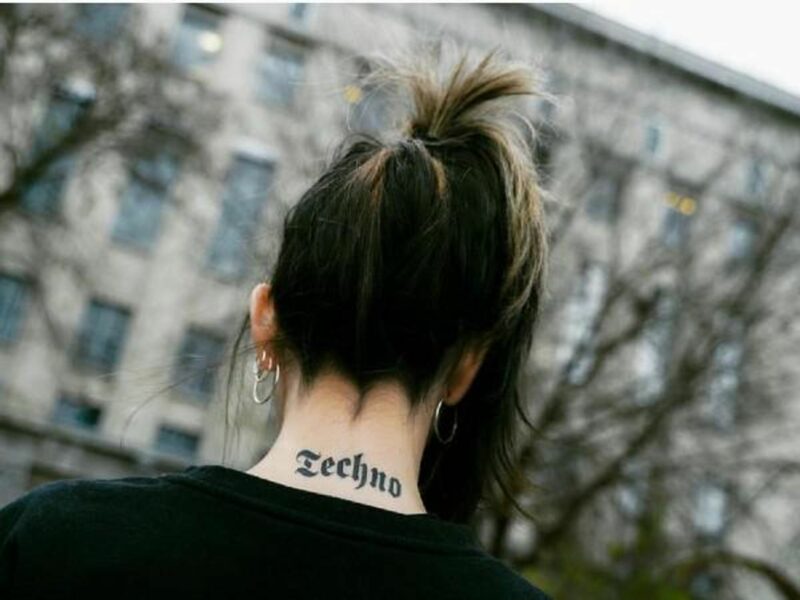 A woman with a "Techno" tattoo in front of the famous Berghain​