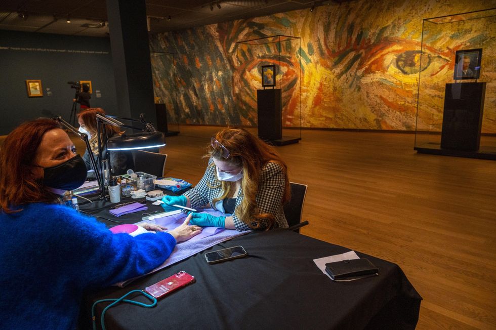 a women getting her nails done by a nail technician in the Van Gogh Museum in Amsterdam