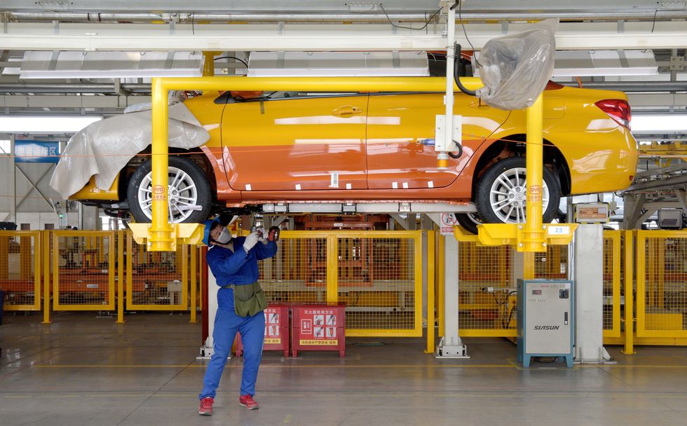 A worker works on the assembly line at a factory of vehicle manufacturer BYD Auto in Xi'an, northwest China's Shaanxi Province, Feb. 25, 2020.