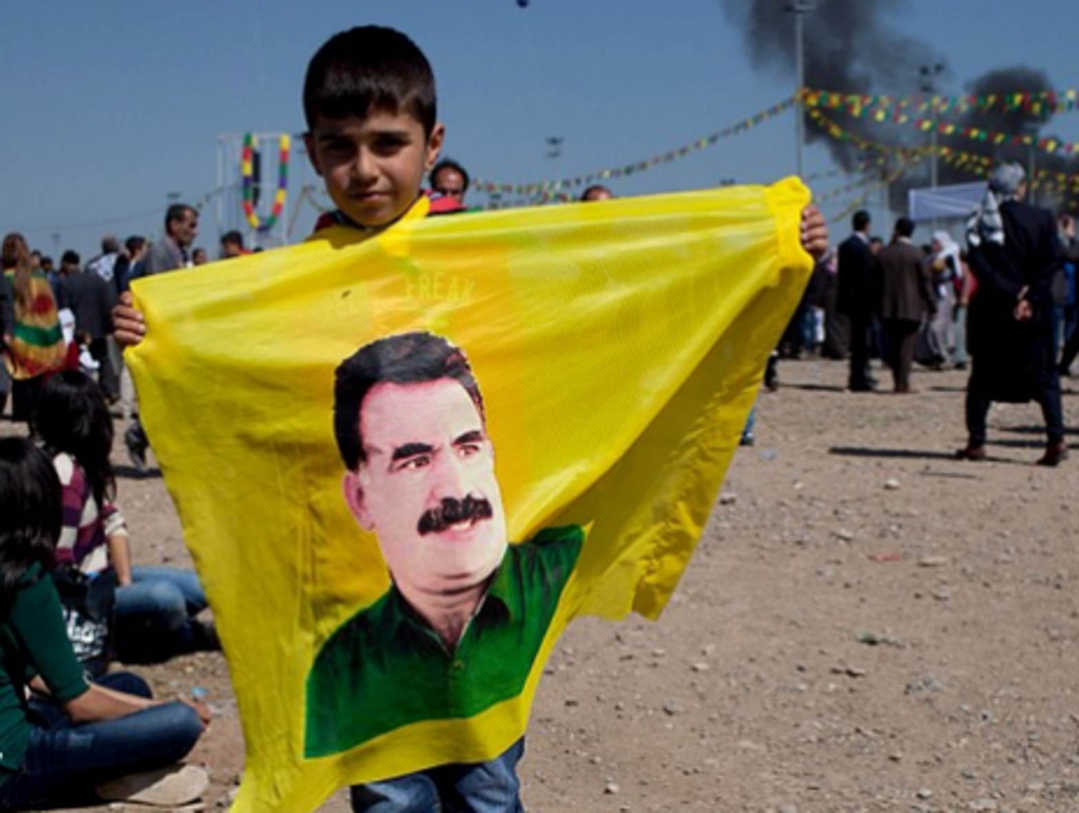A young boy holds a flag with Ocalan's face at the Newroz celebrations