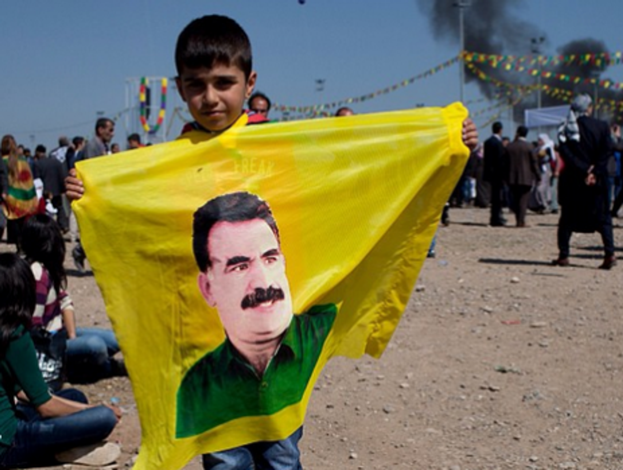 A young boy holds a flag with Ocalan's face at the Newroz celebrations