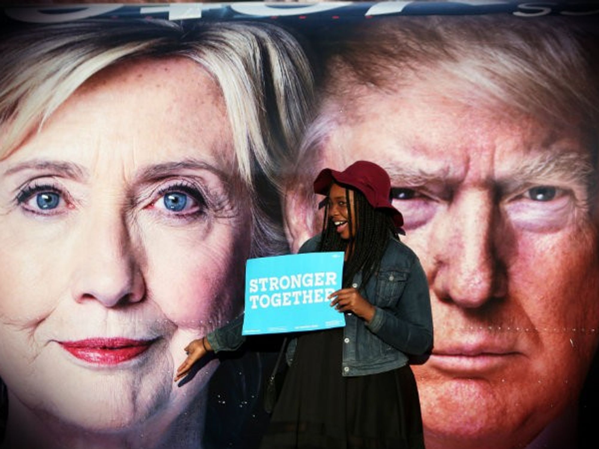 A young Clinton supporter poses in front of posters of the two candidates before Monday's debate.