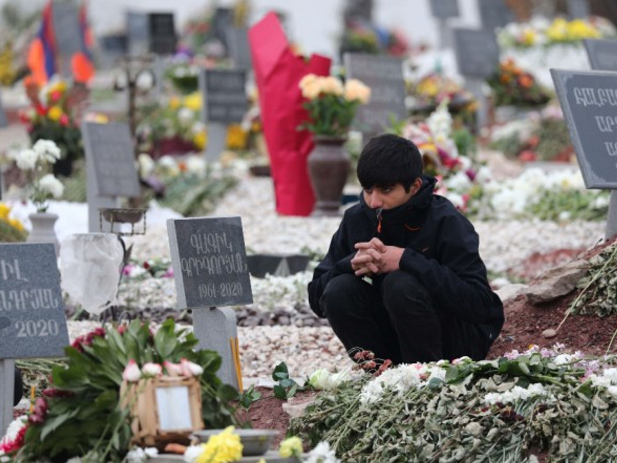 A young man visits the grave of an Armenian serviceman killed during the Nagorno-Karabakh conflict in Yerevan