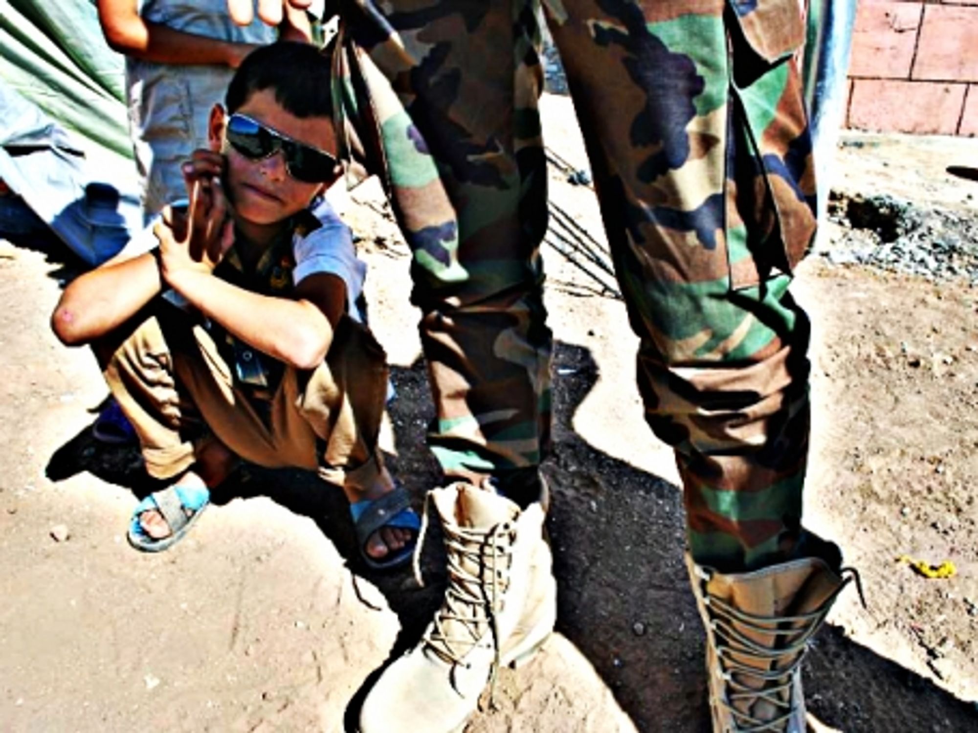 A young Syrian Kurd near a Syrian Kurdish soldier