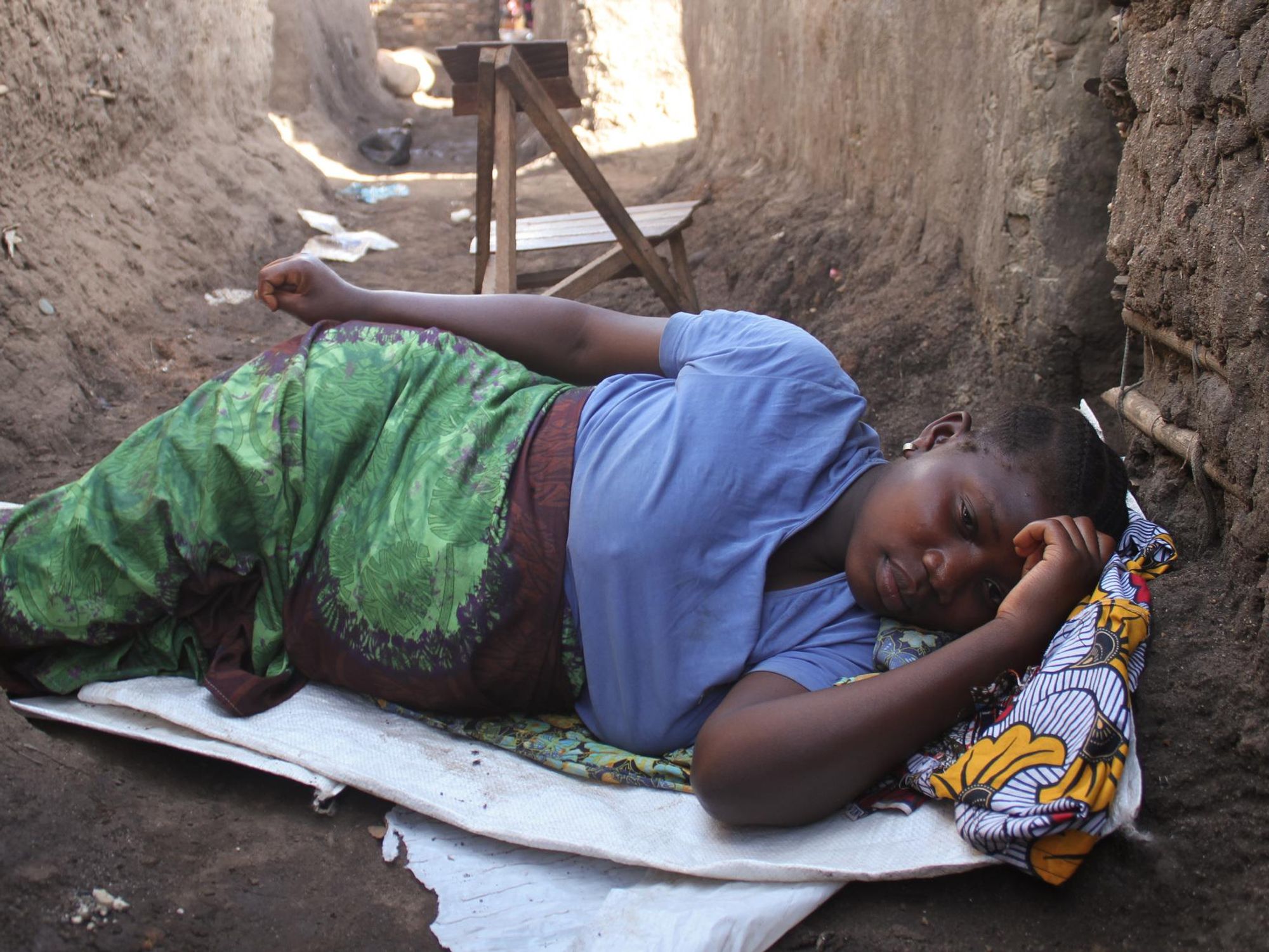 A young woman, pregnant, laying on the ground