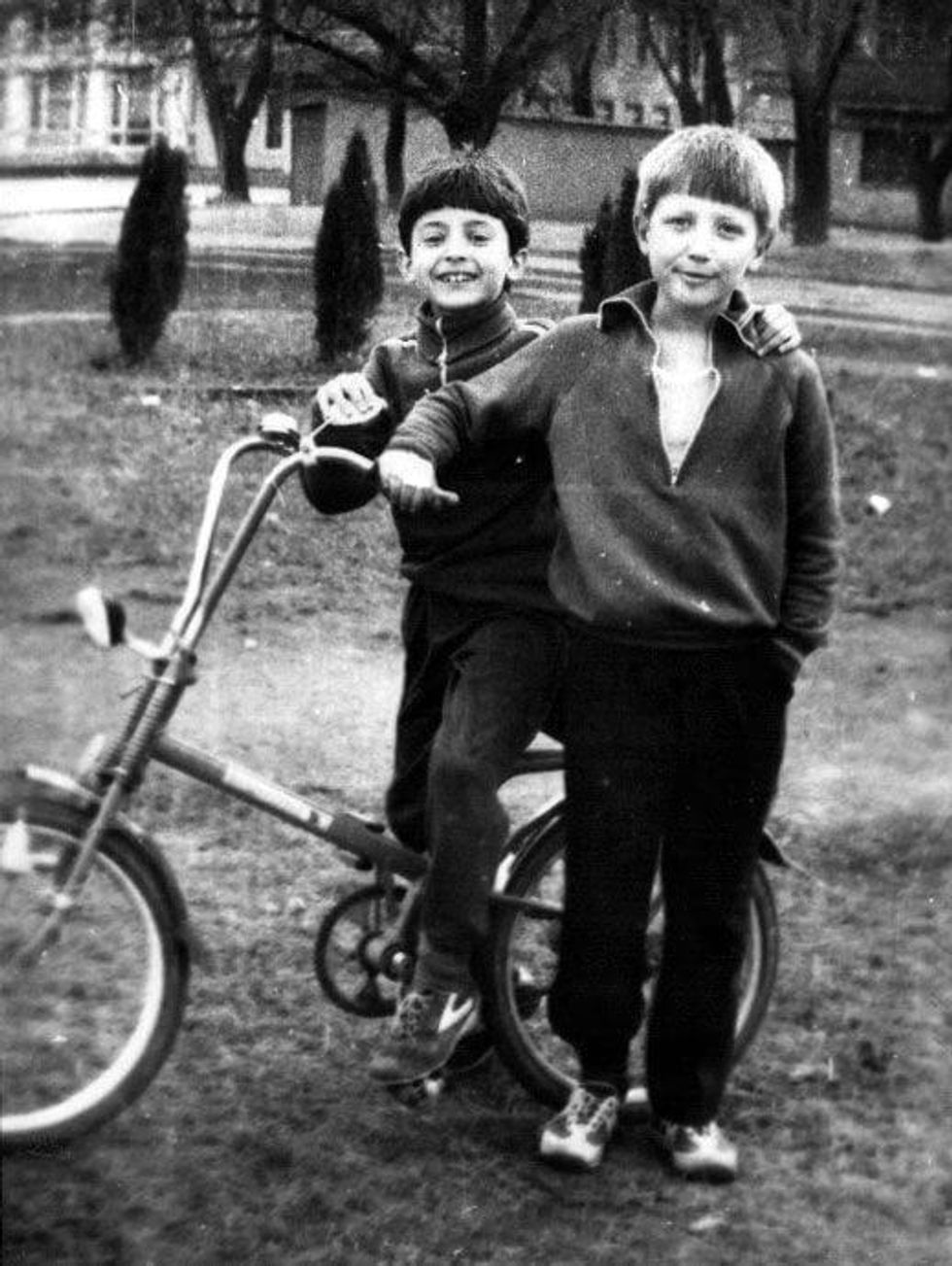 A young Zelensky and a friend on a bike.