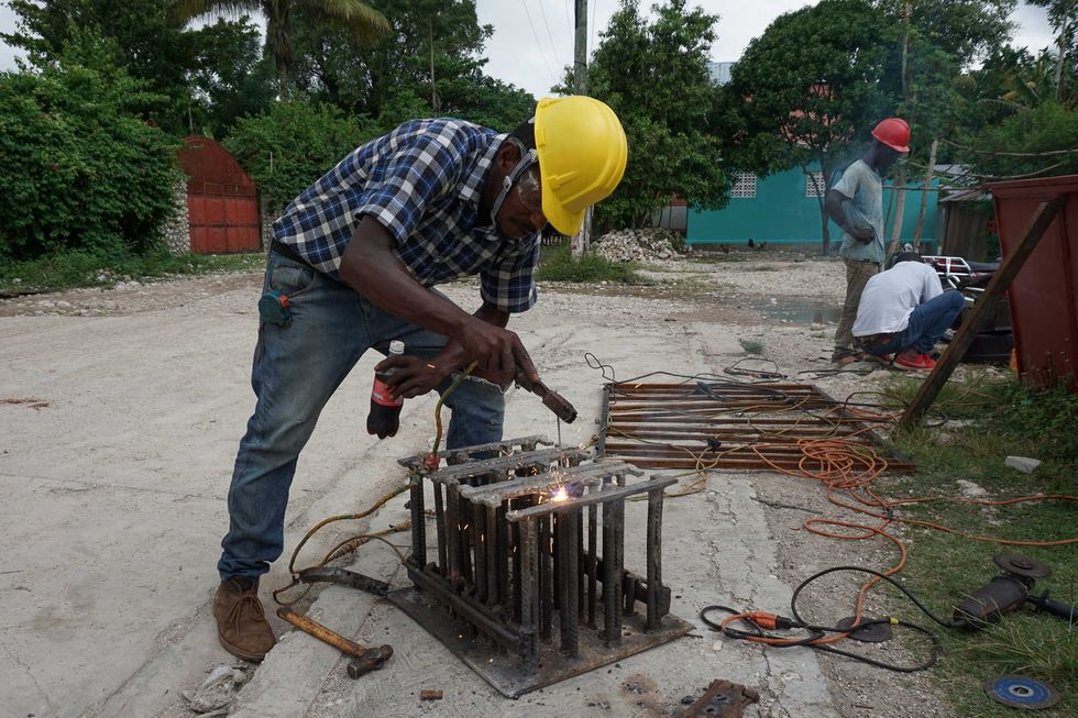 Abaky Labossière welds at his workshop in downtown Maniche, Haiti. Abaky powers his business by generator since an August 2021 earthquake destroyed his workshop and Maniche’s only power-generating hydroelectric plant.