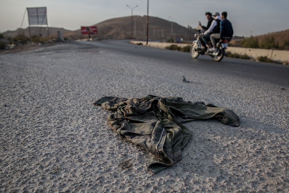 Abandoned military uniforms on a road outside Damascus following the ousting of President Bashar al-Assad