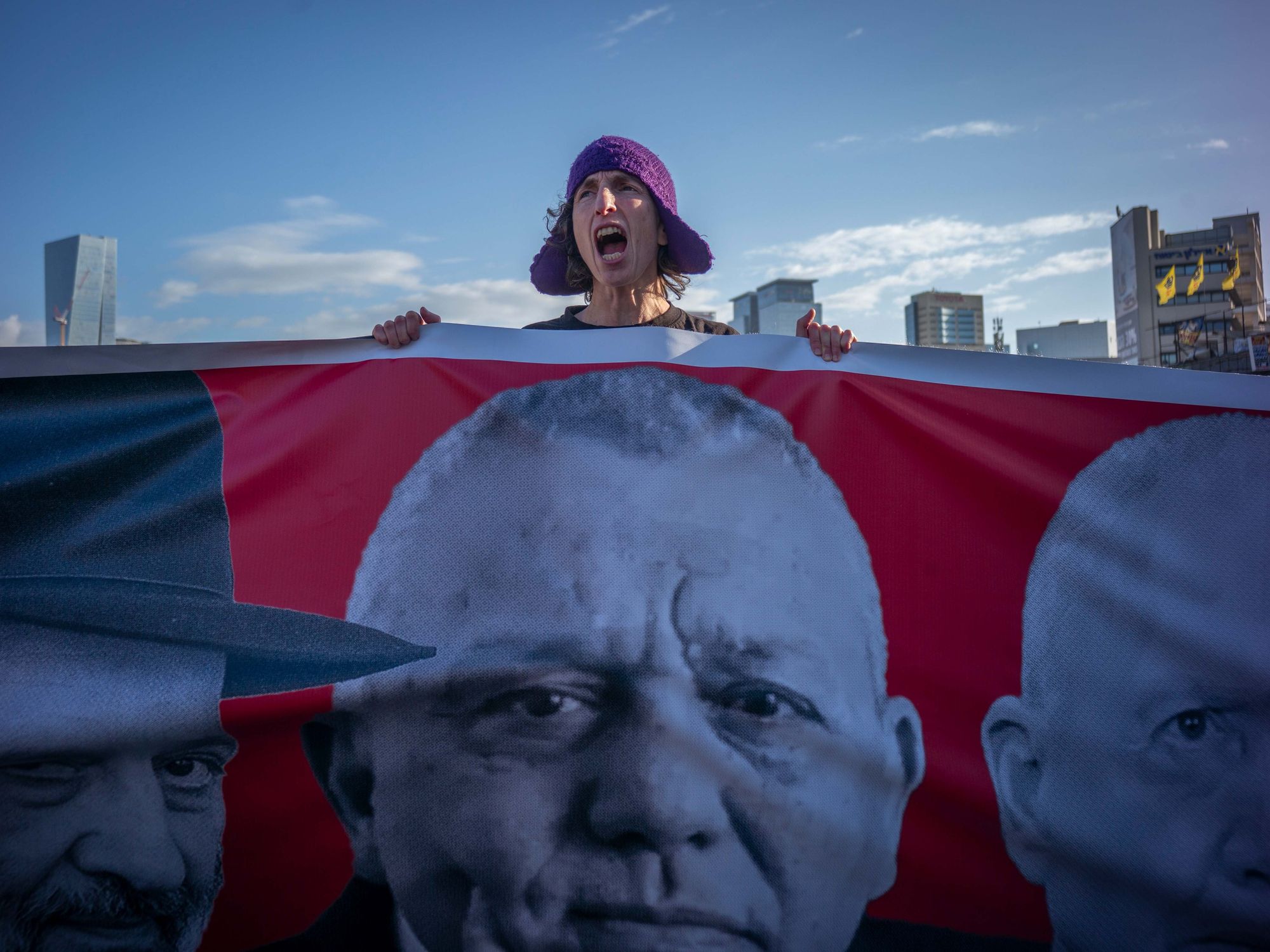 Activists block a highway and hold posters.