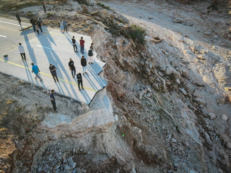 Aerial photo shows people standing on the broken highway between Derna City and Sousse City in east Libya