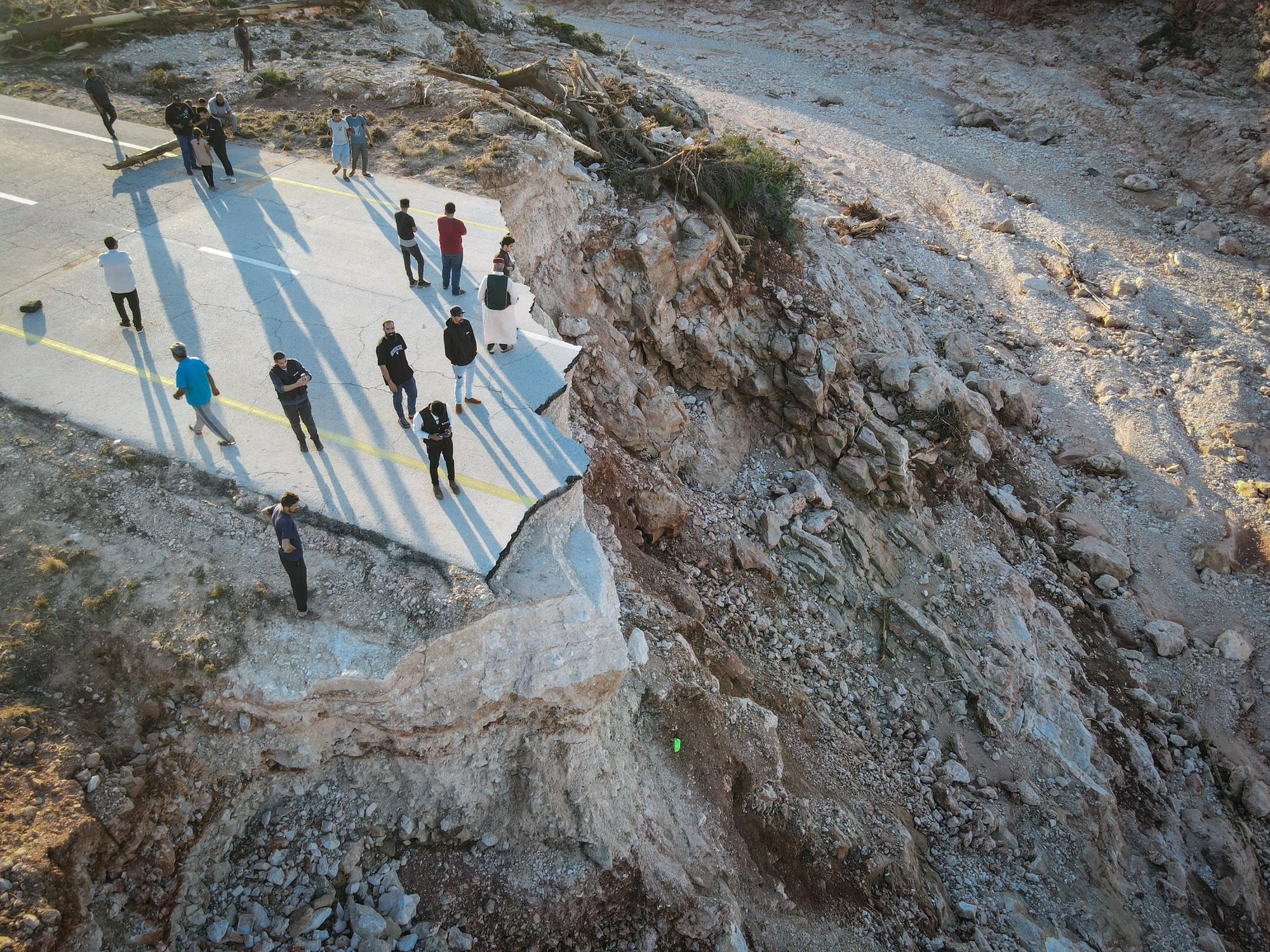 Aerial photo shows people standing on the broken highway between Derna City and Sousse City in east Libya