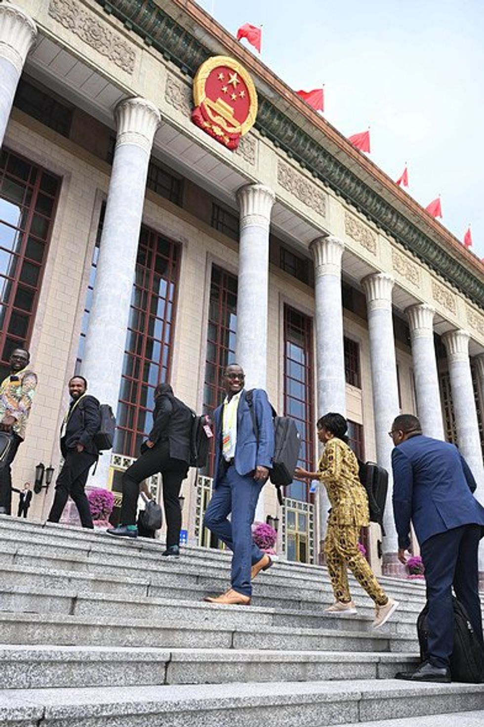 African journalists walking up steps to enter the Great Hall of the People before the opening of the 2024 Summit