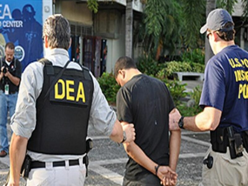 Agents escort a defendant for processing in San Juan, Puerto Rico