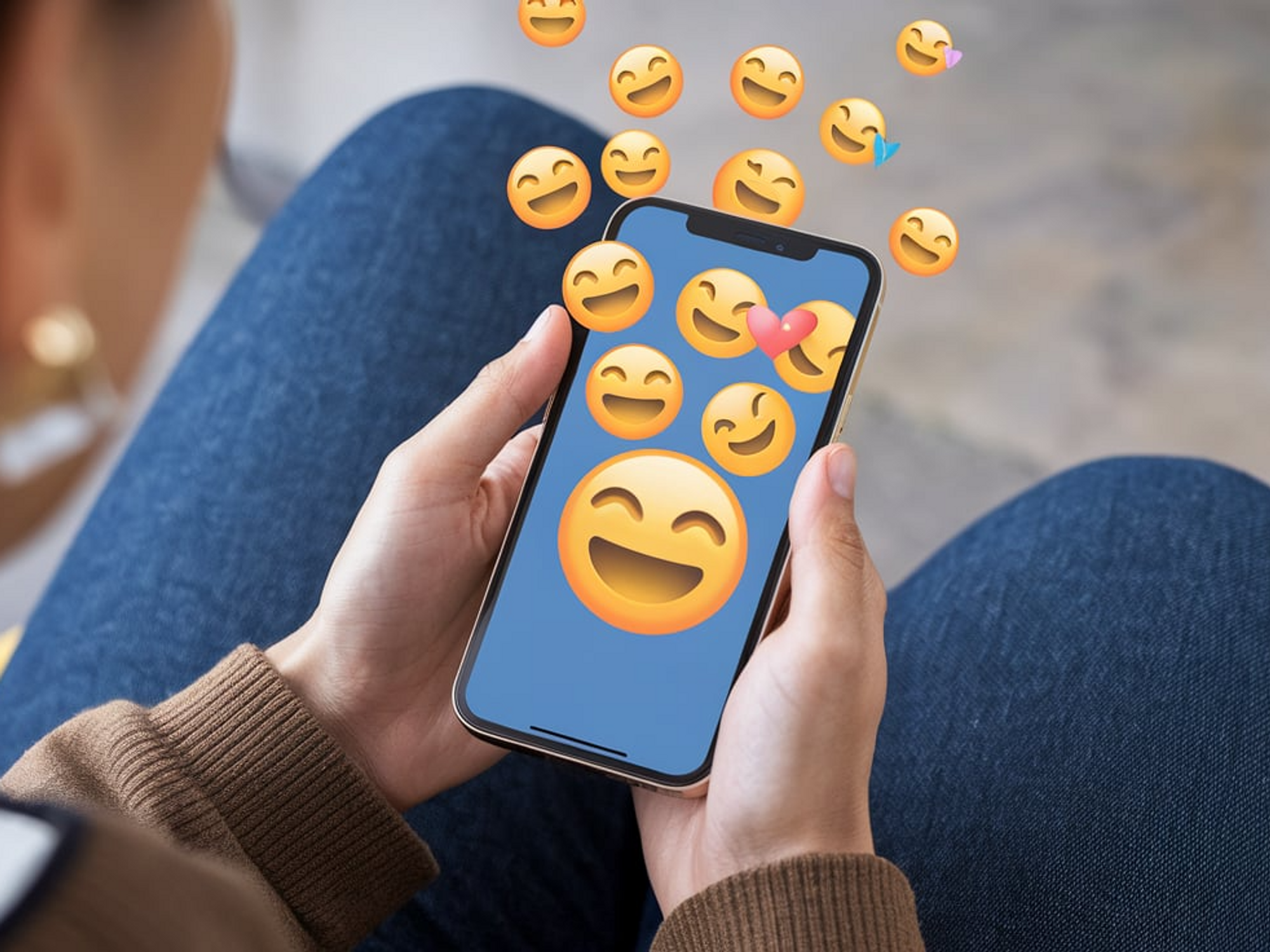 Ai-generated image of a person holding a smartphone from which smiley emojis rise