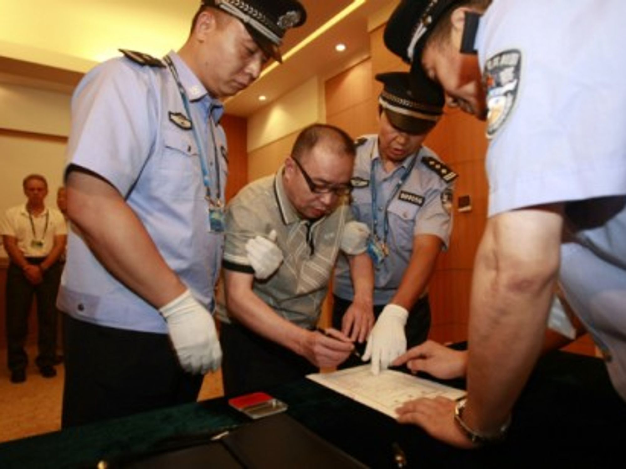 Alleged smuggling kingpin Lai Changxing signs a warrant issued for his arrest as he arrives at the Beijing Capital International Airport on July 23, 2011.