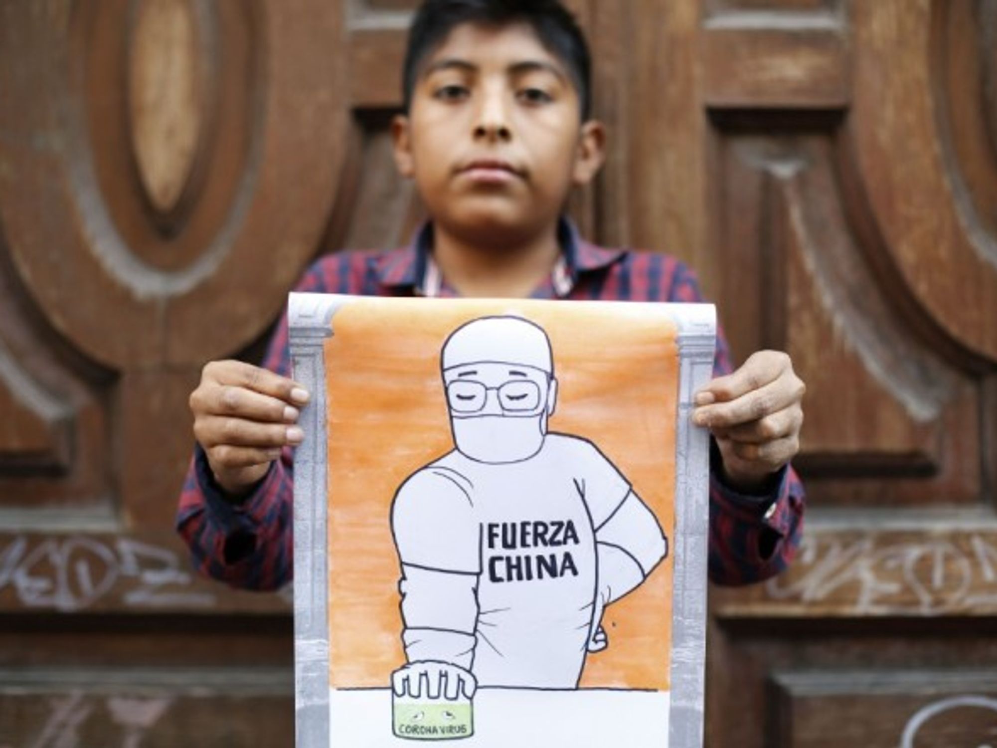 An 11-year-old Mexican boy displays his drawing in support of China's fight against the novel coronavirus.