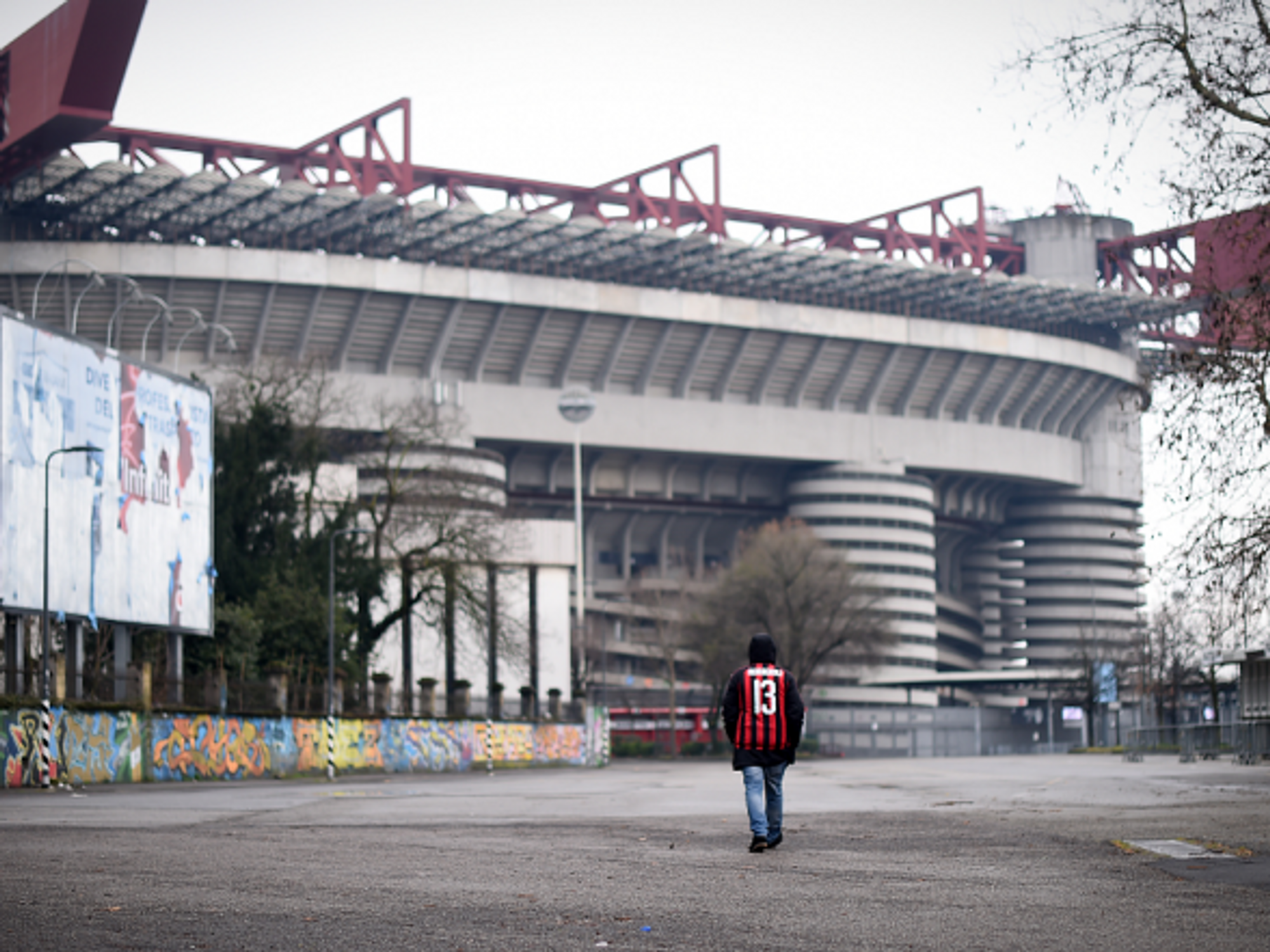 An AC Milan fan outside the iconic San Siro stadium in March 2020