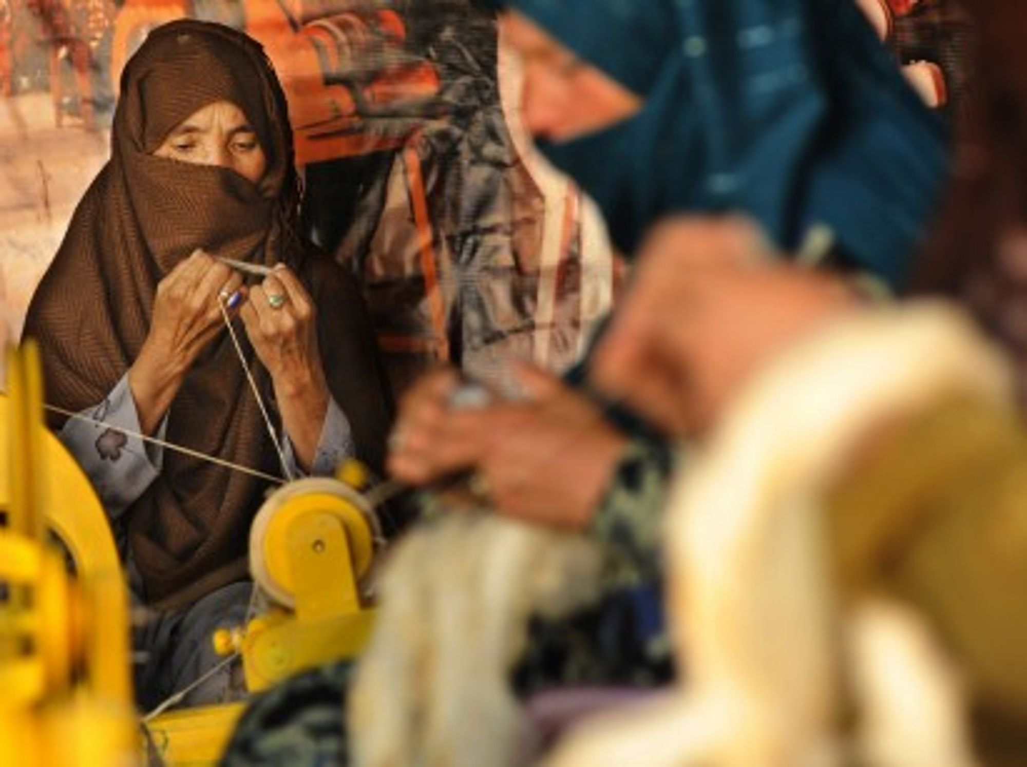 An Afghan woman spins wool into yarn in Kabul (isafmedia)