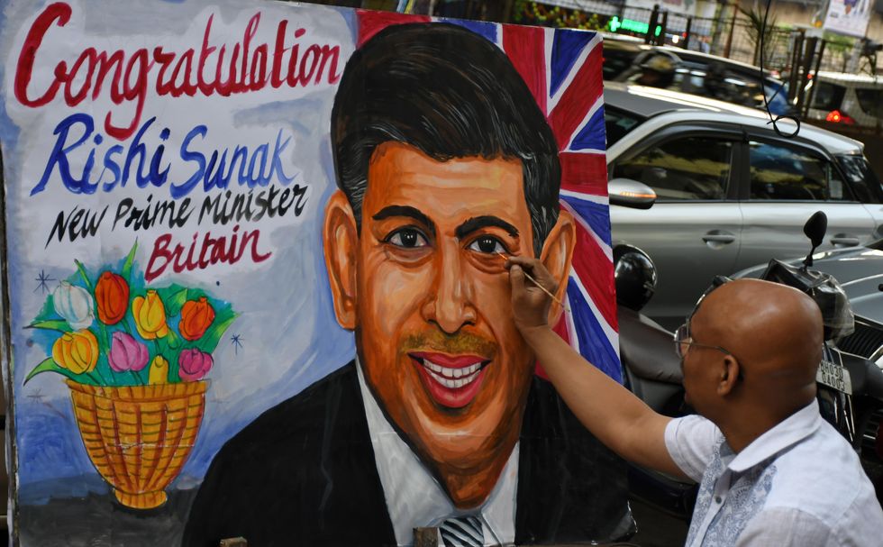 An artist puts the finishing touches to the painting of Rishi Sunak at the Gurukul school of art in Mumbai