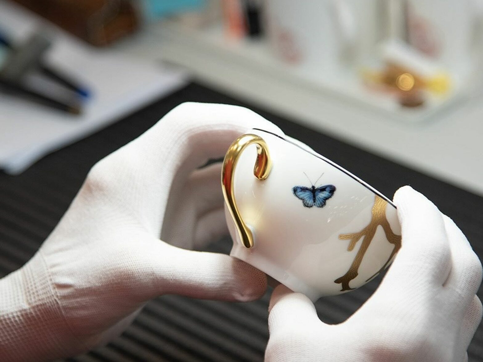 An ​artisan at the Bernardaud manufacture checking a porcelain cup.