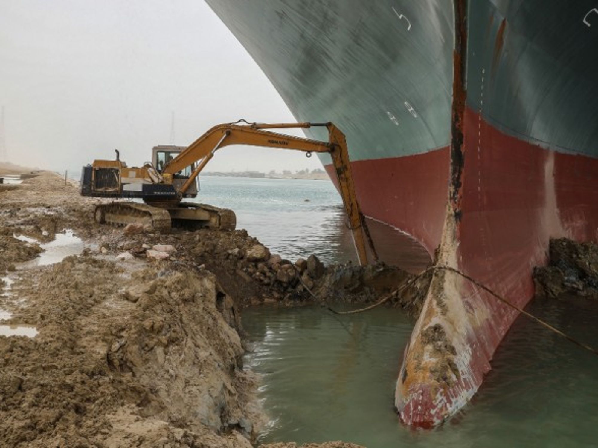 An excavator attempts to free the front end of the Ever Given, the container ship which is currently blocking the Suez Canal
