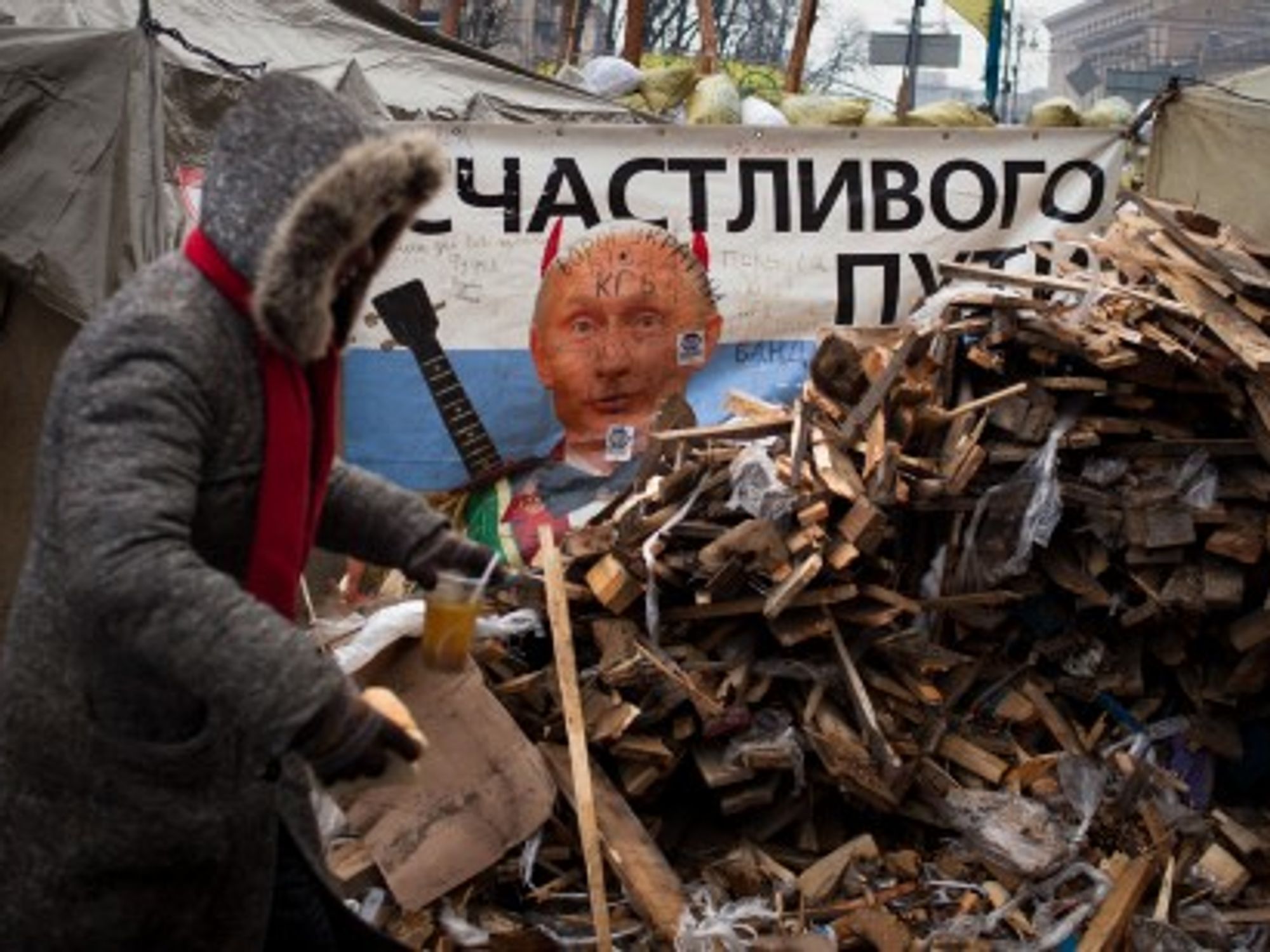 An image of President Putin peeks from behind barricades in Independence Square, Kiev.