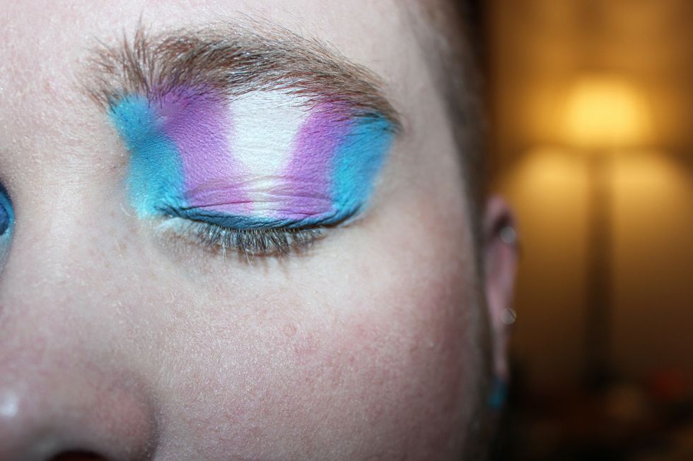 An image of the transgender flag painted on eyelids.
