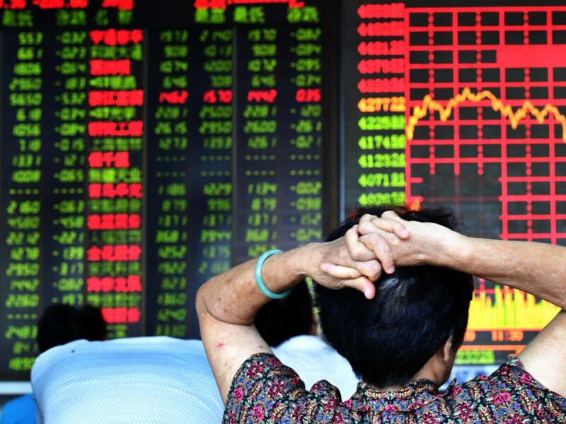 An investor looks through stock information at a trading hall in a securities firm in Haikou, capital of southeast China's Hainan Province.