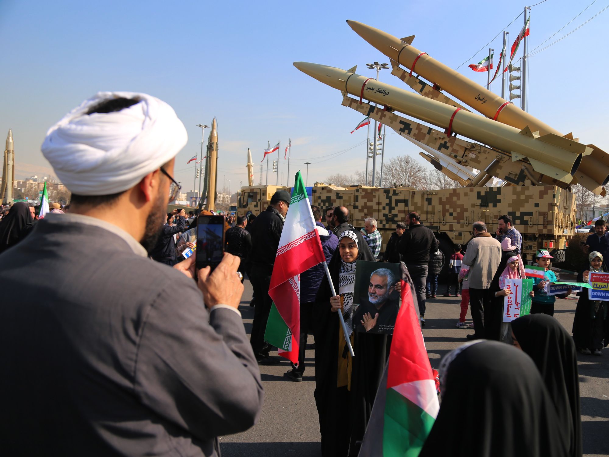 An Iranian clergyman takes a photo next to the Iranian-made missiles at Azadi (freedom) Square in Tehran as people gather to mark the 45th anniversary of the Islamic revolution in Tehran.