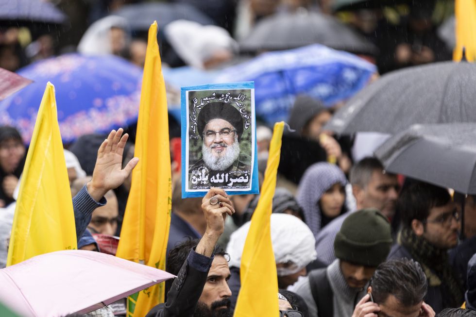 An Iranian demonstrator holds a poster of Hezbollah leader Hassan Nasrallah during a gathering to support the militant group in Tehran.