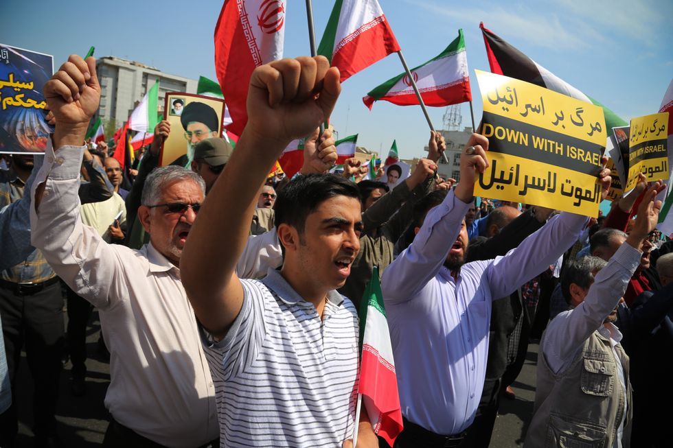 An Iranian man carries a placard written ''DOWN WITH ISRAEL'' during an anti-Israel rally in Tehran.