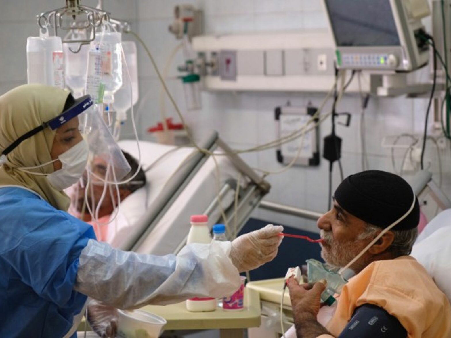 An Iranian medical personnel feeding a patient in a hospital in southern Tehran