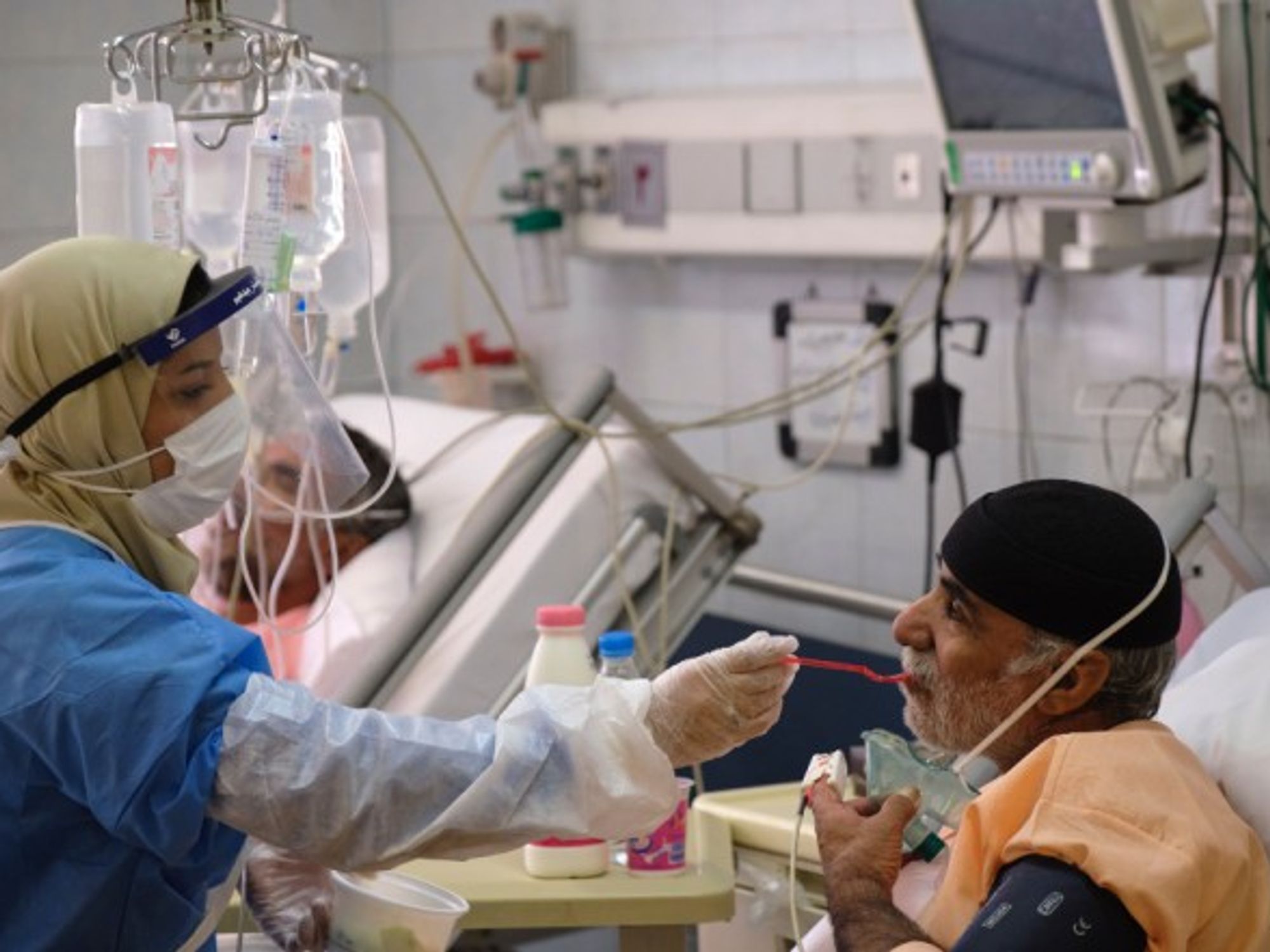 An Iranian medical personnel feeding a patient in a hospital in southern Tehran