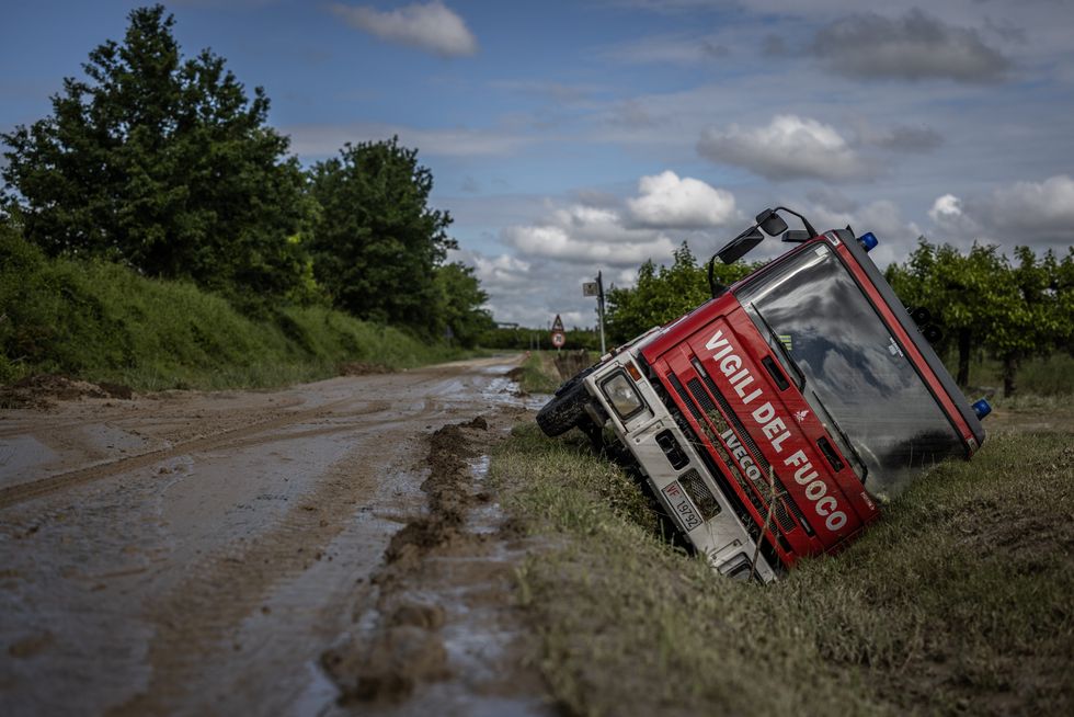 An Italian fire truck lies in a ditch following heavy floods.