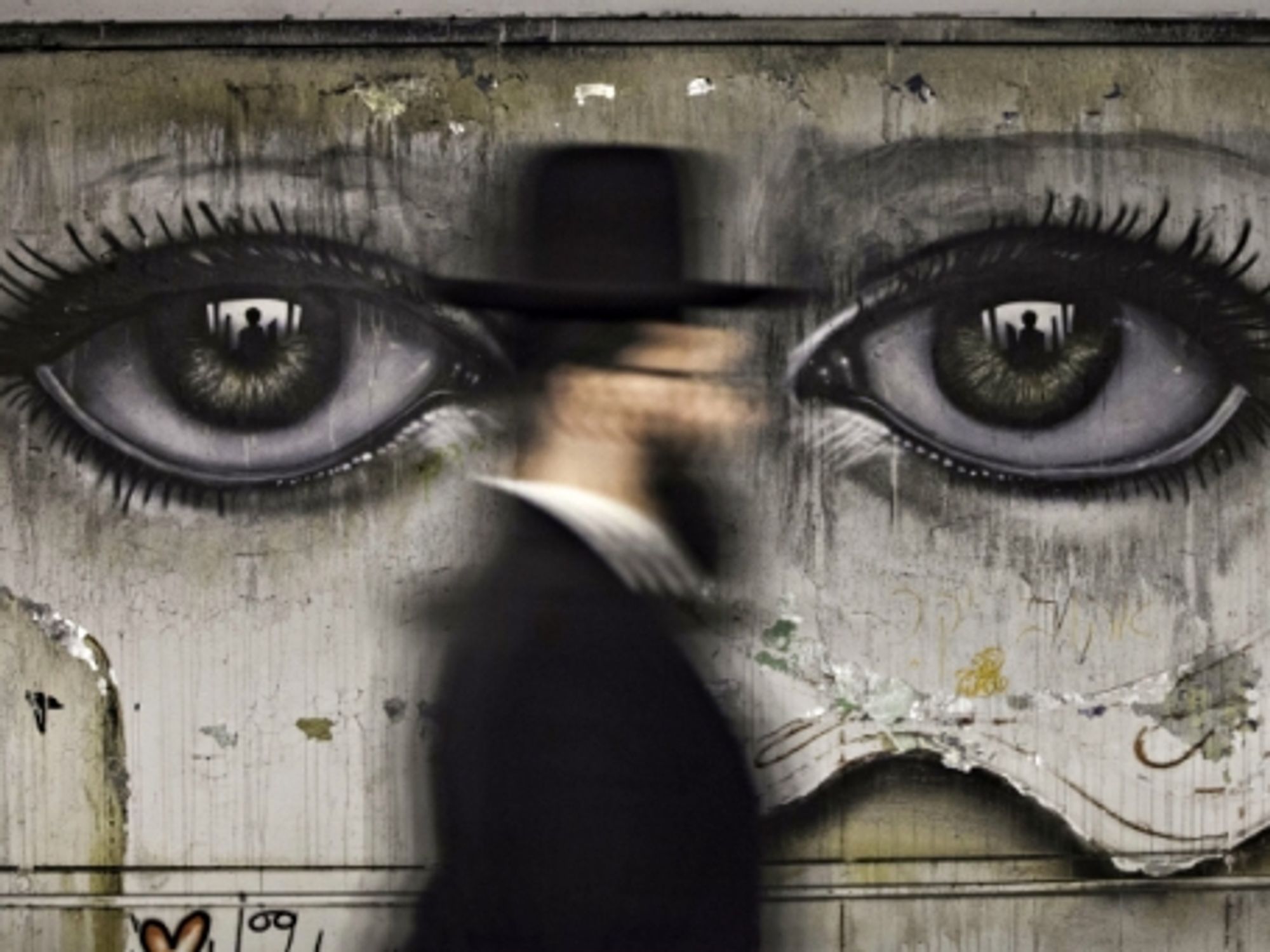 An ultra-Orthodox Jew walks past graffiti in Jerusalem