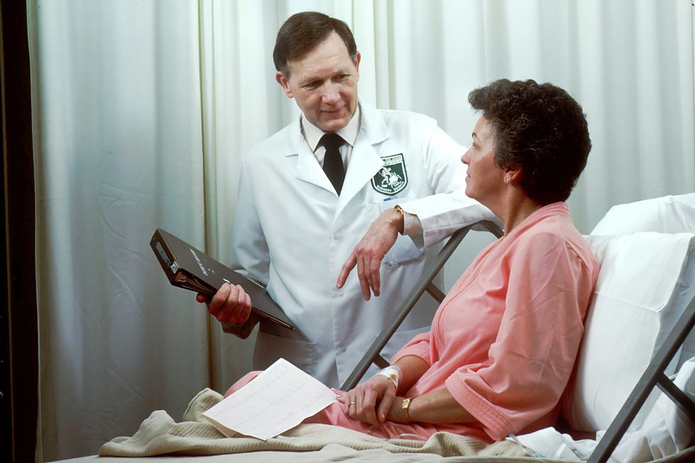 Archive photo of a male doctor examining a woman in a hospital