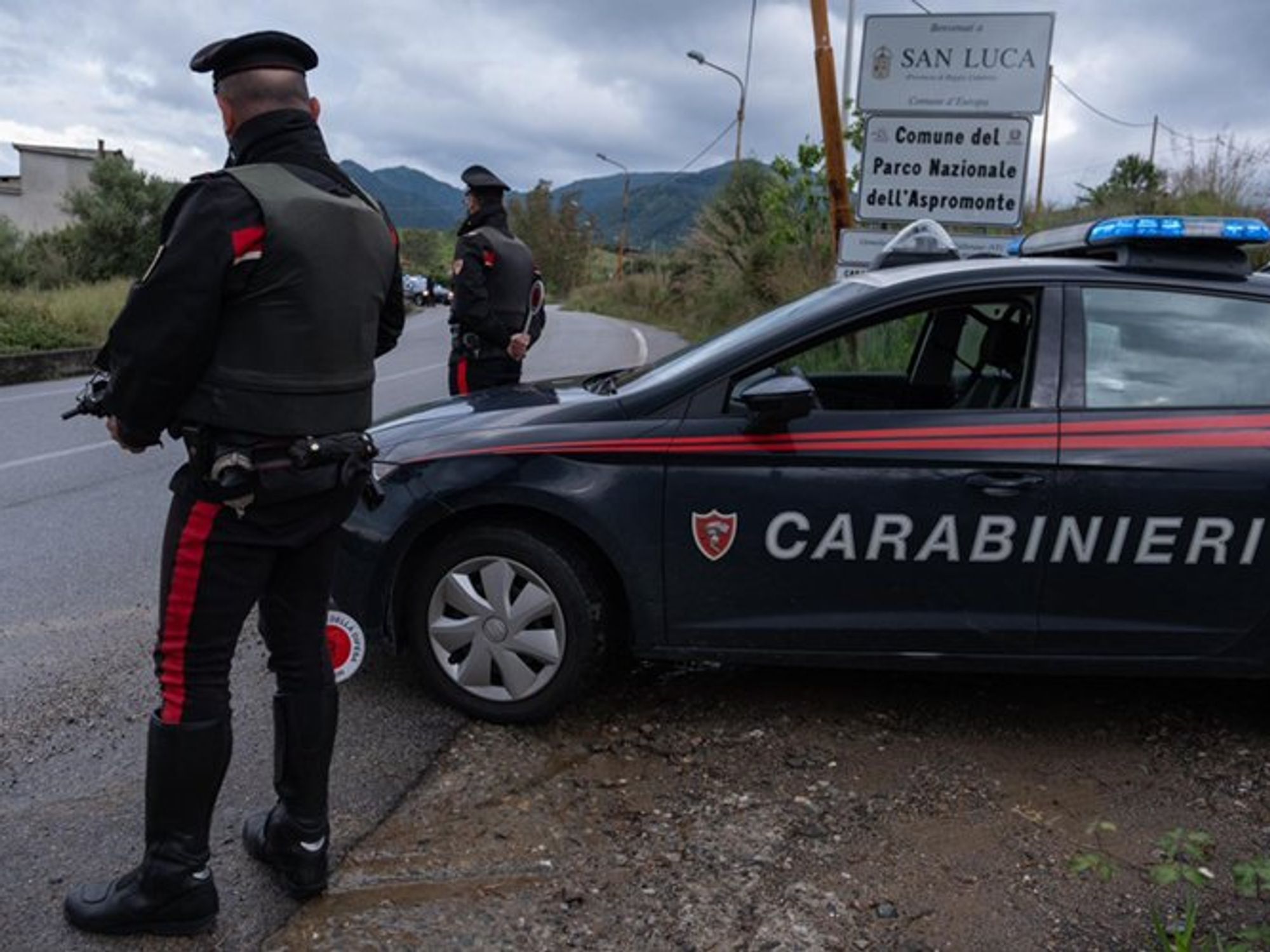Armed Italian Carabinieri and their vehicule by the side of the road at San Luca