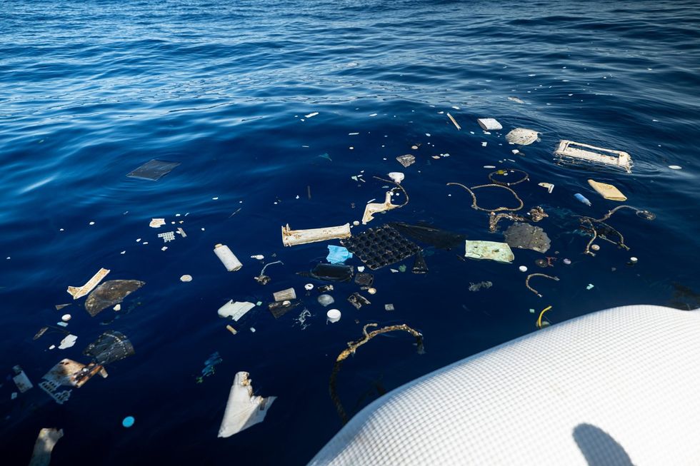 Assorted trash in the ocean off the side of a boat
