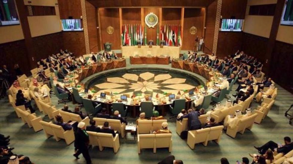 Attendees sit in a large circle at the Arab League Meeting ​